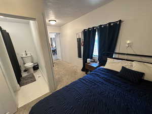 Bedroom with carpet flooring and a textured ceiling