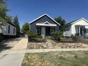 View of front of home featuring a gate, a fenced front yard, a porch, and driveway