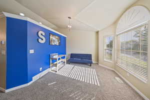 Sitting room featuring carpet flooring and vaulted ceiling