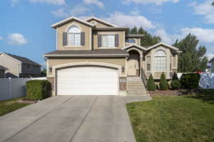 View of front facade with driveway, an attached garage, stucco siding, and brick siding