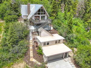 Aerial view of property and surrounding area with a forest