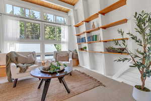 Living area with carpet flooring, plenty of natural light, and wood ceiling