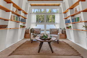 Sitting room featuring plenty of natural light, carpet floors, and wooden ceiling