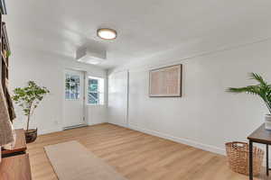 Entrance foyer with light wood finished floors and a textured ceiling