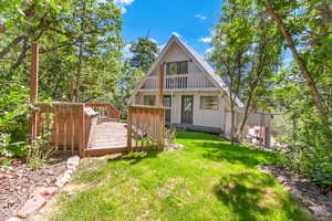 Back of house with a wooden deck and a balcony