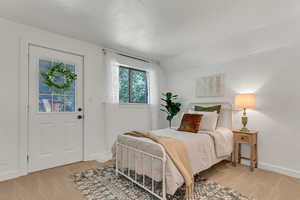 Bedroom with light colored carpet and vaulted ceiling