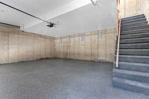 Garage featuring a garage door opener and epoxied floor