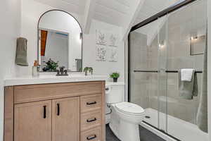 Full bathroom featuring vanity, a stall shower, vaulted ceiling, and tile patterned floors