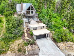 Aerial view of property and surrounding area with a heavily wooded area
