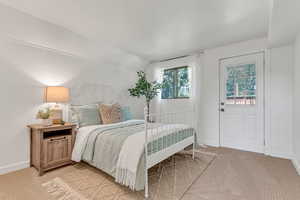 Bedroom featuring light colored carpet and lofted ceiling