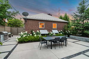 Patio terrace at dusk with outdoor dining area, a patio, and a grill
