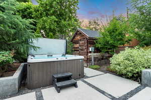 Patio terrace at dusk featuring a hot tub and a patio