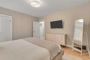 Bedroom with light wood-style floors and baseboards