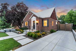 View of front facade featuring brick siding and a gate