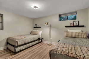 Bedroom with wood finished floors and baseboards