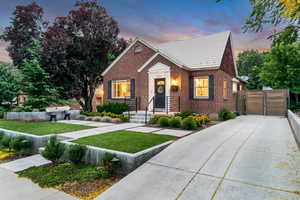 View of front of home with brick siding and a gate