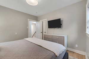 Bedroom with wood finished floors and baseboards
