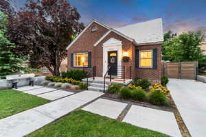 Bungalow-style home with brick siding and a gate