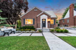 Bungalow-style home featuring brick siding and a lawn