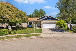 Single story home with concrete driveway, an attached garage, a front yard, and brick siding