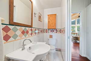 Bathroom with tile walls and a wainscoted wall
