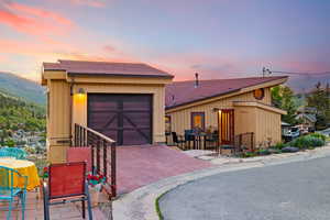 View of front of house featuring a garage, a mountain view, and decorative driveway