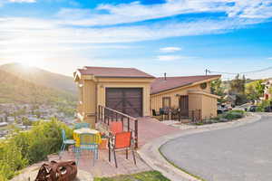 View of front facade with a mountain view, a patio area, and a garage
