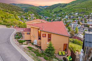 Property exterior at dusk with a mountain view and a shingled roof