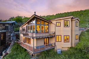 Back of property at dusk with a balcony