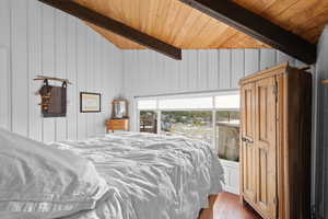 Bedroom featuring wooden ceiling, wood finished floors, and wood walls