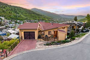 View of front of property featuring a mountain view, a garage, decorative driveway, and roof with shingles