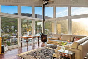 Sunroom featuring a wood stove and wood finished floors