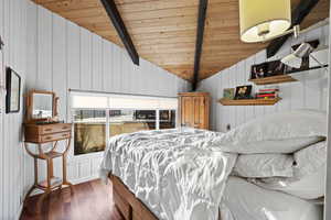 Bedroom featuring wood ceiling, wood finished floors, and wood walls