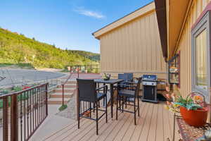 Deck with area for grilling, outdoor dining space, and a mountain view