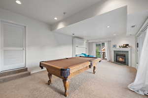 Game room with light colored carpet, recessed lighting, billiards table, and a tiled fireplace