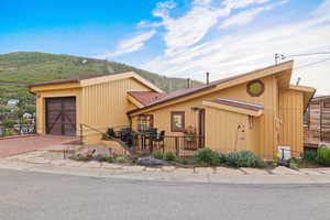 View of front of house with a mountain view and decorative driveway
