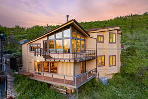Back of property at dusk with a balcony