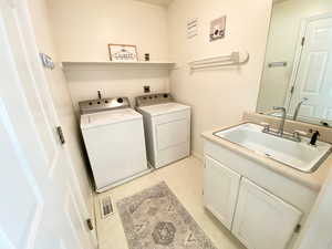 Laundry area featuring washing machine and dryer and cabinet space