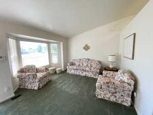 Carpeted living area featuring baseboards