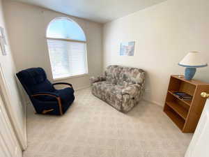 Sitting room with light colored carpet and baseboards