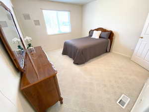 Bedroom with light colored carpet and baseboards