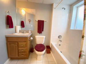 Full bath featuring vanity, tile patterned flooring, washtub / shower combination, and healthy amount of natural light