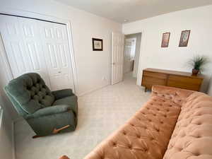 Living area featuring light carpet and baseboards