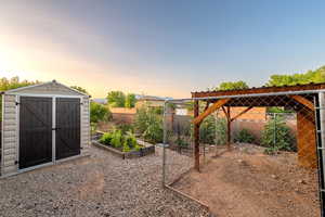 View of yard featuring a vegetable garden and a storage unit