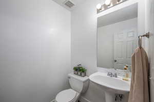 Half bath featuring toilet and a sink