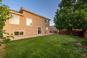 Rear view of house featuring a fenced backyard, a patio area, and stucco siding