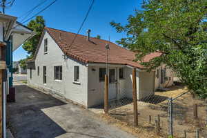 Back of property with a tile roof and stucco siding