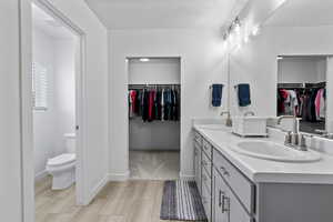 Primary bathroom with double vanity and spacious walk-in closet