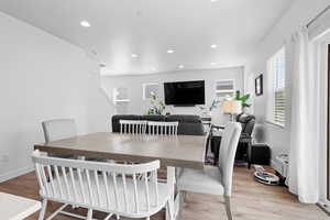Dining room featuring light wood-type laminate floors and recessed lighting