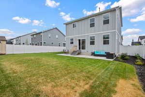 Rear view of property featuring board and batten siding, outdoor lounge area, entry steps, a patio area, and a fenced backyard